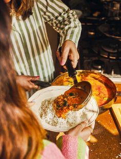 a woman is serving food to another woman