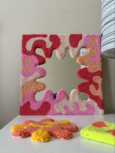 a mirror sitting on top of a table next to two crocheted sponges