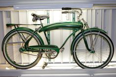 a green bicycle is parked in front of a window