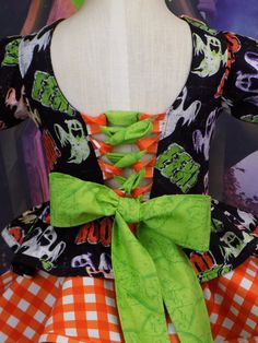 a dress made out of fabric with an orange and green bow