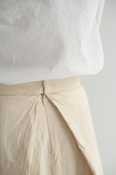 Casey Casey Moon Skirt in Ecru. Pleated skirt in washed cotton with a tailored waist and back button and zip closure. Front pleats hide pockets, while the back pleat creates volume. Lined in cotton. 99% cotton, 1% polyester, 100% cotton lining. Made in France. XS - 27" waist, 33" lengthS - 28" waist, 34" length Asymmetrical Cotton Skirt In Beige, Beige Cotton Asymmetrical Skirt, Beige Asymmetrical Cotton Skirt, Beige Pleated Asymmetrical Skirt, Cotton Bottoms With Pleated Hem For Daywear, Cotton Asymmetrical Skirt For Daywear, Cotton Asymmetrical Skirt With Pockets, Long Cotton Skirt With Pleated Hem, Cotton Gathered Skirt Bottoms For Work