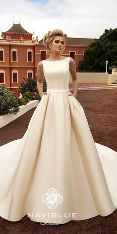 a woman in a white wedding dress standing outside