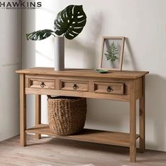 a wooden table with two drawers and a potted plant