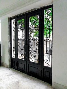 a black double door with wrought iron designs