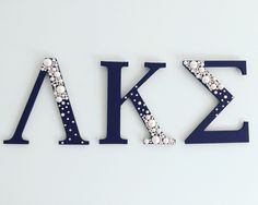 the letters are made up of pearls and blue plastic with white polka dots on them