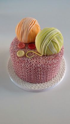 there are two balls of yarn on top of the cake