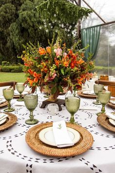 the table is set with plates, cups and vases for dinner guests to enjoy