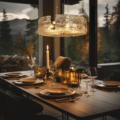 a dining room table set with plates and candles