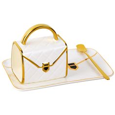 a white and gold handbag sitting on top of a tray