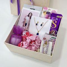 a gift box filled with jewelry and personal items for someone's birthday or special occasion