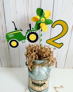 a metal bucket with some paper flowers in it and a number two on the top