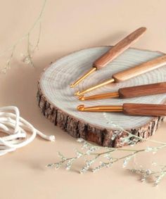 four wooden spoons sitting on top of a piece of wood