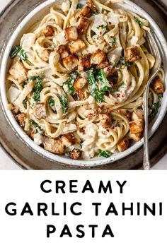 creamy garlic tahitii pasta with chicken and spinach in a white bowl on a gray plate