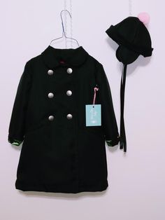 "This is a classic girls size 4, black double breasted polyester Garbardine coat. This fall/ winter coat has six silver buttons in the front with a hidden black button inside near neckline. It has long set in sleeves,collar and welt pockets(also lined). This coat comes with a black hat with contrasting lining with ear flaps to keep her ears warm with black satin ribbons to tie it close, pink Pom Pom finishes off with a touch of softness on top. The coat if fully lined with a dropped lining,pink Winter Costume Double-breasted Outerwear, Classic Black Costume Outerwear, Black Winter Uniform Outerwear, Pink Pom Pom, Fall Winter Coat, Formal Coat, Classic Girl, Satin Ribbons, Silver Buttons