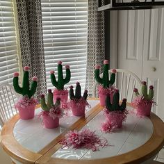 a table topped with pink and green cactus plants