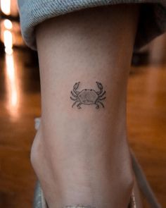 a small crab tattoo on the right side of the leg, with an arrow in it's center