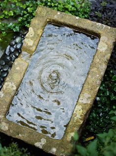 a square stone fountain with water in it