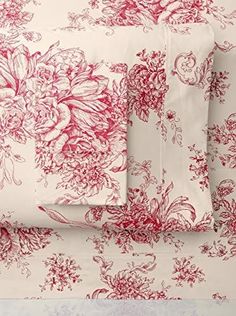 red and white floral bedding with matching pillowcases on top of each other