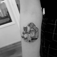 a woman with a cat tattoo on her left arm and the image of an angel holding a kitten