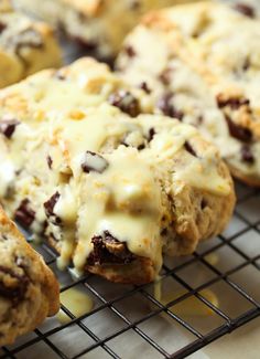 chocolate chip cookies with cheese drizzled over them are cooling on a wire rack