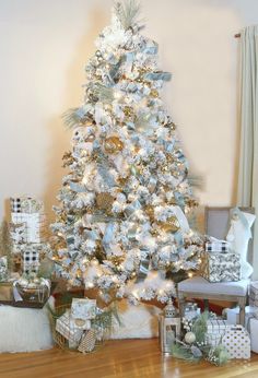 a white christmas tree with silver and gold ornaments