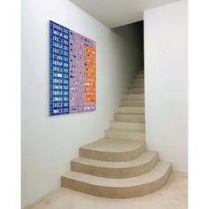 there is a painting on the wall next to some stairs in an empty room with white walls