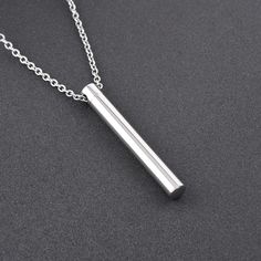 a silver bar necklace on a chain