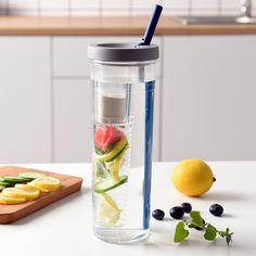 a water bottle filled with fruits and vegetables next to a cutting board on a counter