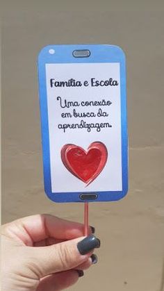 a person holding up a sign with a heart on it that says familia e escola