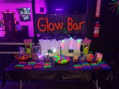 a table with neon lights and glow bar decorations