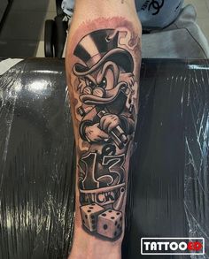 a man with a tattoo on his leg that has dice in the shape of a cartoon character