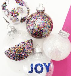 christmas ornaments with the word joy written on them and colored sprinkles around them