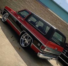 a red and black truck parked in front of a building