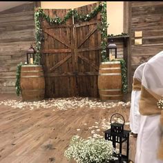 the ceremony room is decorated with white flowers and greenery, along with wooden barrels