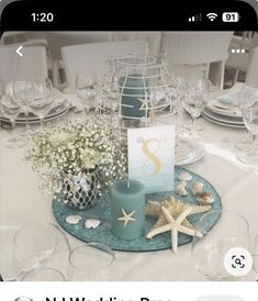 the table is set with starfish and seashells for an ocean themed wedding