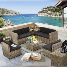 an outdoor living area with wicker furniture overlooking the ocean