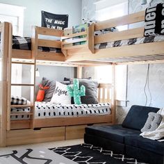 a bedroom with bunk beds and pillows on the bottom bunk, next to a black couch