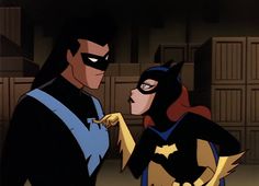 batman and catwoman standing next to each other