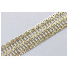 a gold metal bracelet on a white background