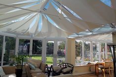 a sun room filled with lots of windows and furniture