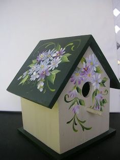 a bird house with flowers painted on it