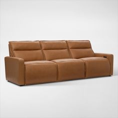 a brown leather couch sitting on top of a white floor