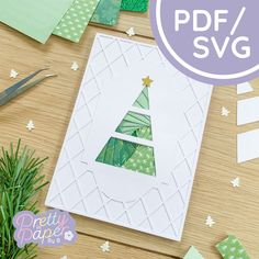 a paper christmas tree on top of a table with scissors and other crafting supplies