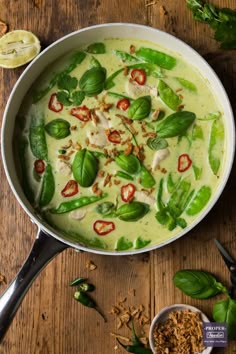 thai green curry recipe in a pan with basil leaves and other ingredients on the side