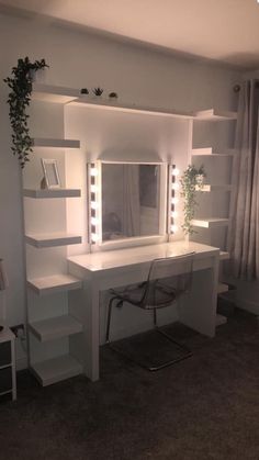 a white desk with lights on it next to a mirror and shelf filled with books