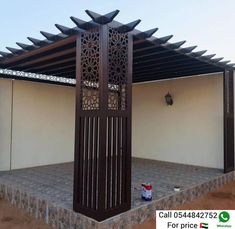 a wooden gazebo sitting next to a white wall