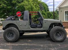 the jeep is parked on the side of the road in front of a stop sign