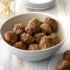 a white bowl filled with meatballs on top of a table