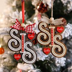 two wooden ornaments hanging from a christmas tree with the word sister and son written on them