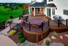 a large deck with a hot tub in the middle and a grill on the other side